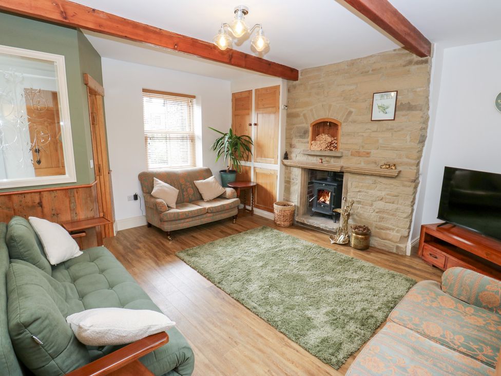 A living room with a sofa and fireplace at Hivewood Cottage in Haworth