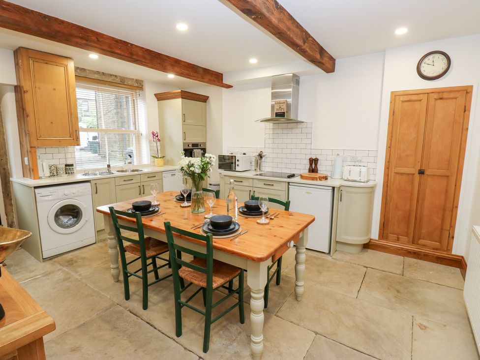 A kitchen with dining table and chairs at Hivewood Cottage in Haworth