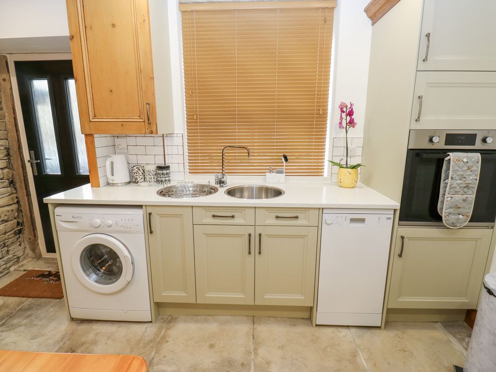 A kitchen with appliances and fixtures at Hivewood Cottage in Haworth