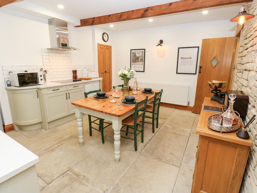 A kitchen with a dining table and chairs at Hivewood Cottage in Haworth