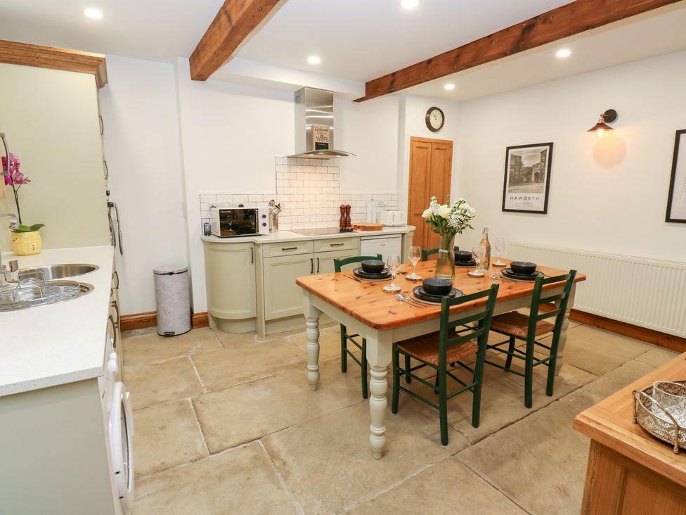 A kitchen with a dining table and chairs at Hivewood Cottage in Haworth