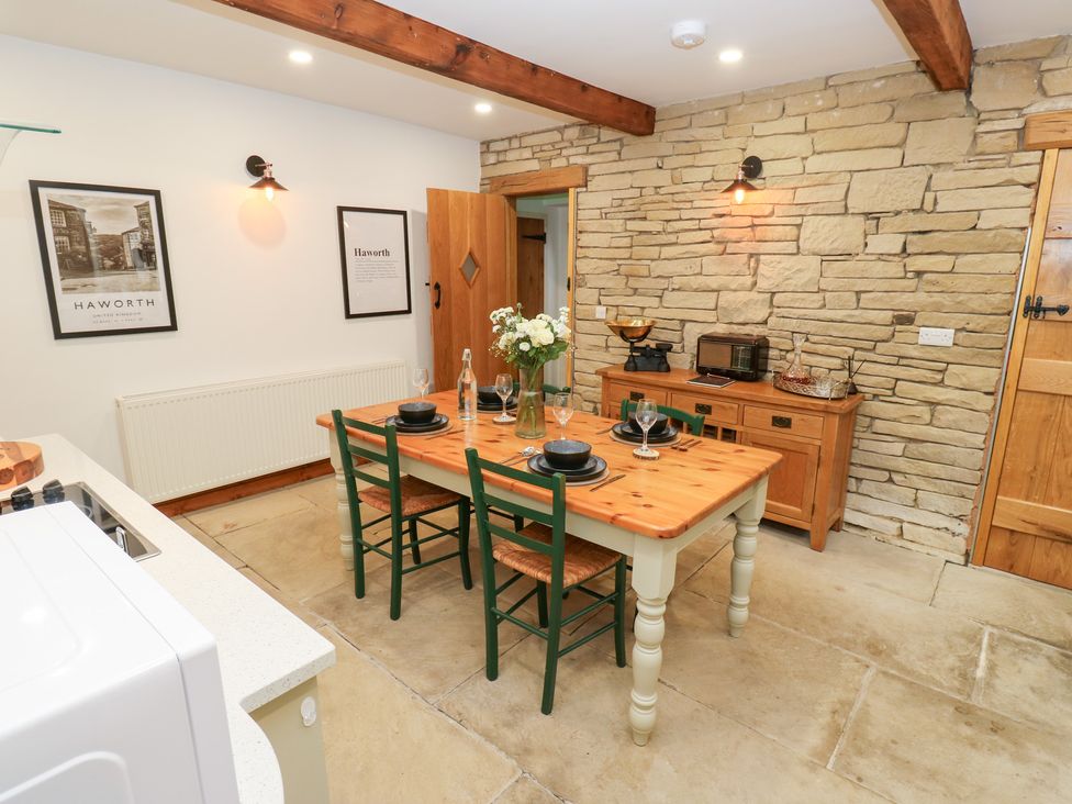 A dining room with a wooden table and chairs at Hivewood Cottage in Haworth