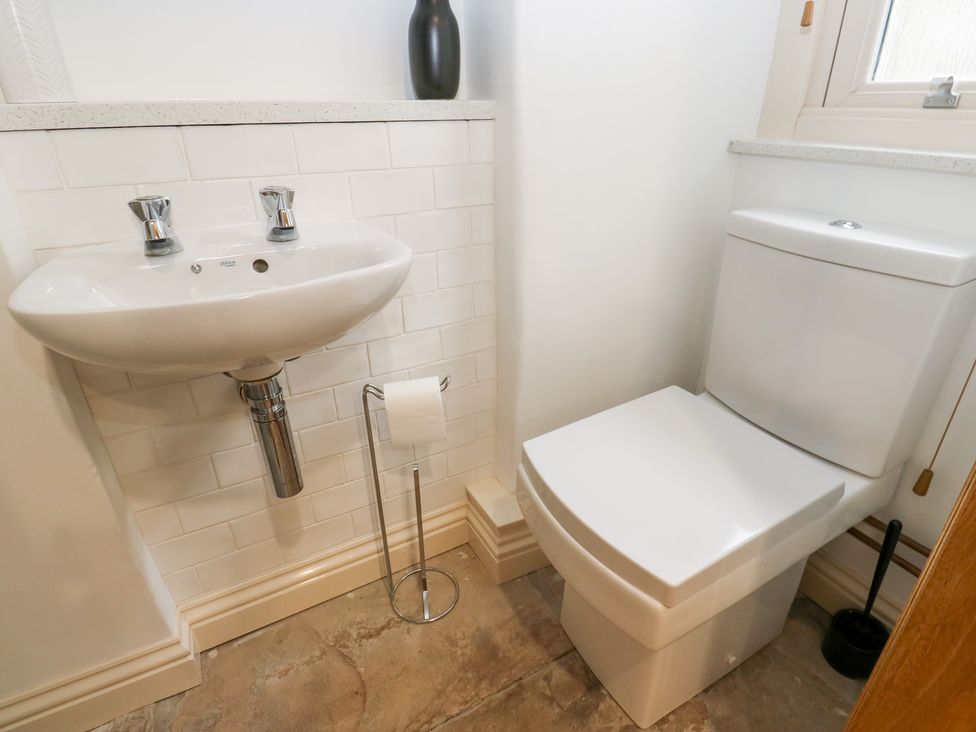 A bathroom with a sink and toilet at Hivewood Cottage in Haworth
