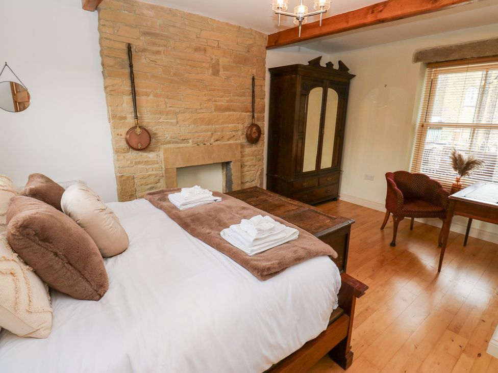 A bedroom with a bed and decorative elements at Hivewood Cottage in Haworth
