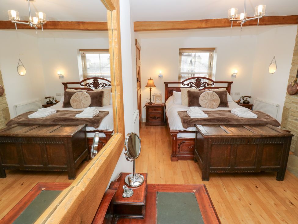A bedroom with a bed and bedside tables at Hivewood Cottage in Haworth