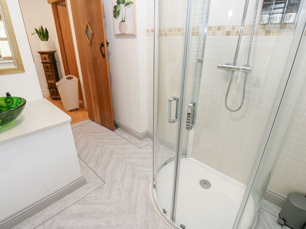 A bathroom with a shower and sink at Hivewood Cottage in Haworth