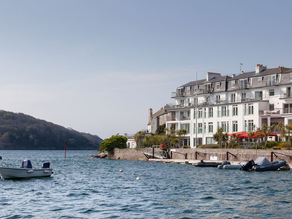 A view of a waterfront building with boats at the dock at 43 The Salcombe in Salcombe