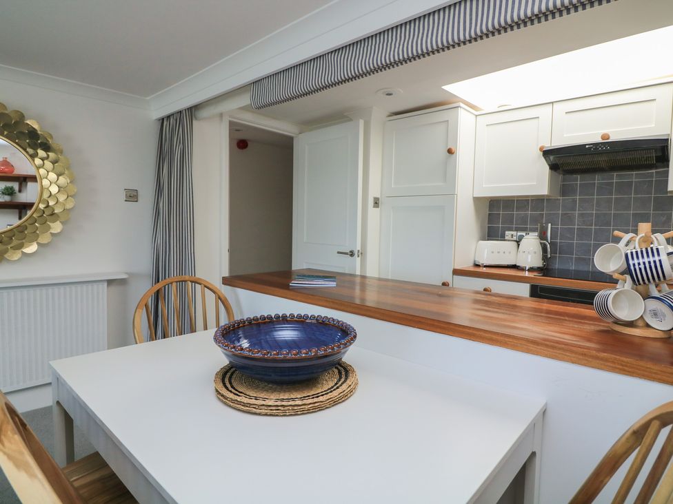 A kitchen with a table and chairs at 43 The Salcombe in Salcombe