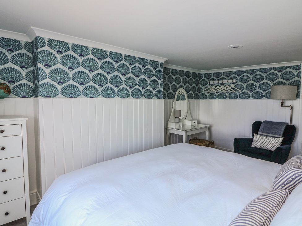 A bedroom with a bed and dressing table at 43 The Salcombe in Salcombe