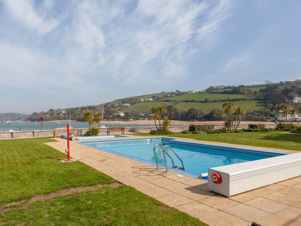 An outdoor swimming pool with a view of hills at 43 The Salcombe in Salcombe