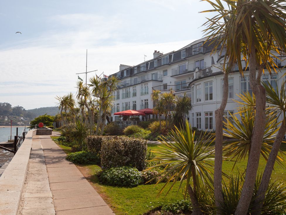 An outdoor area with a building and palm trees at 43 The Salcombe in Salcombe