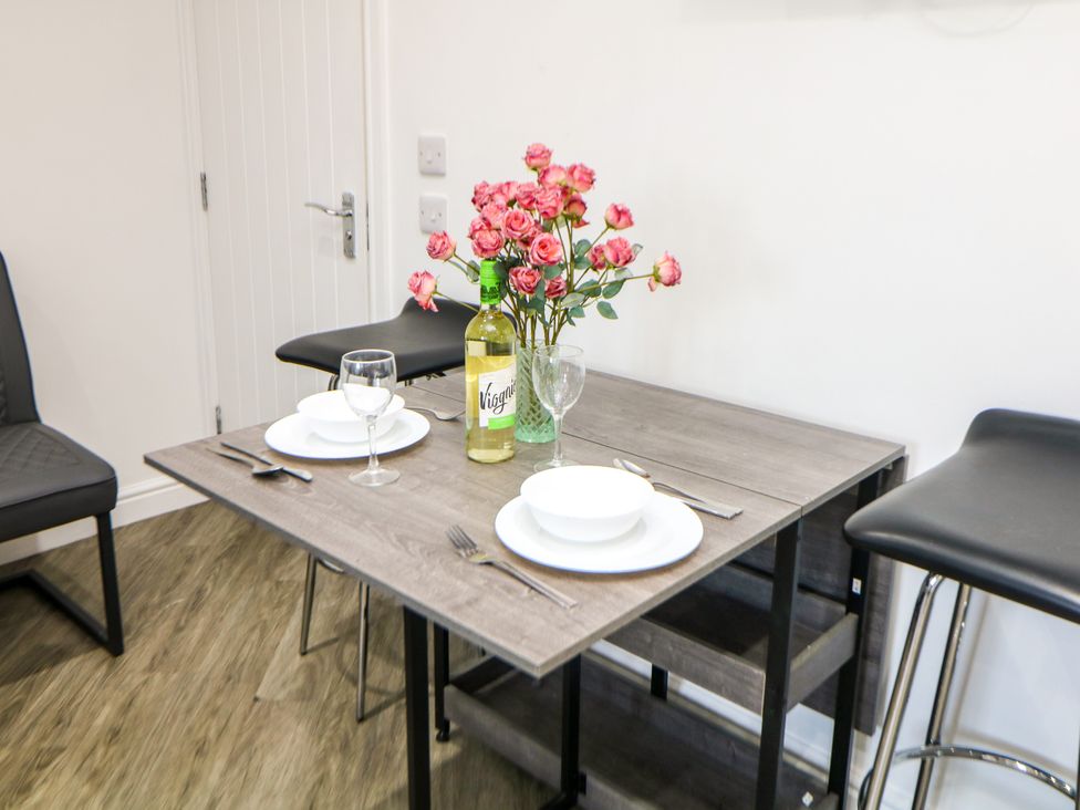 A dining table set with plates and glasses at Don Valley Apartment A 