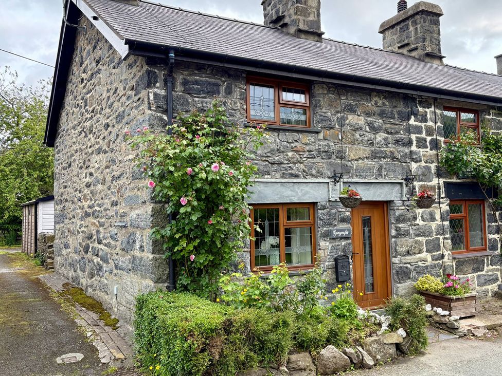 A stone house with a pathway and flowers at Gwynfa in Ysbyty Ifan