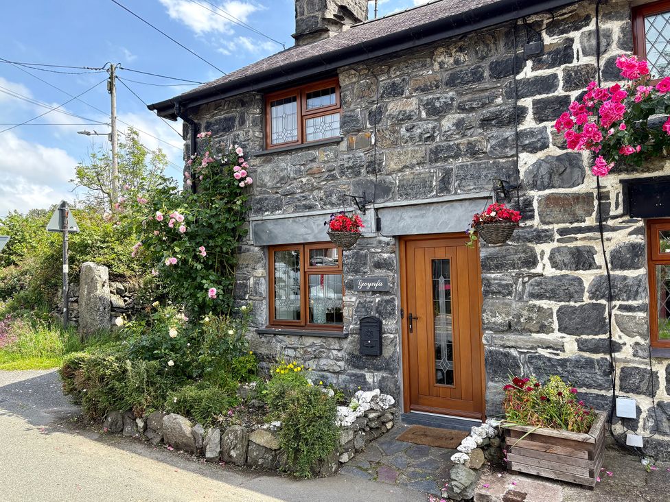 The entrance of Gwynfa with flowers and stone features in Ysbyty Ifan
