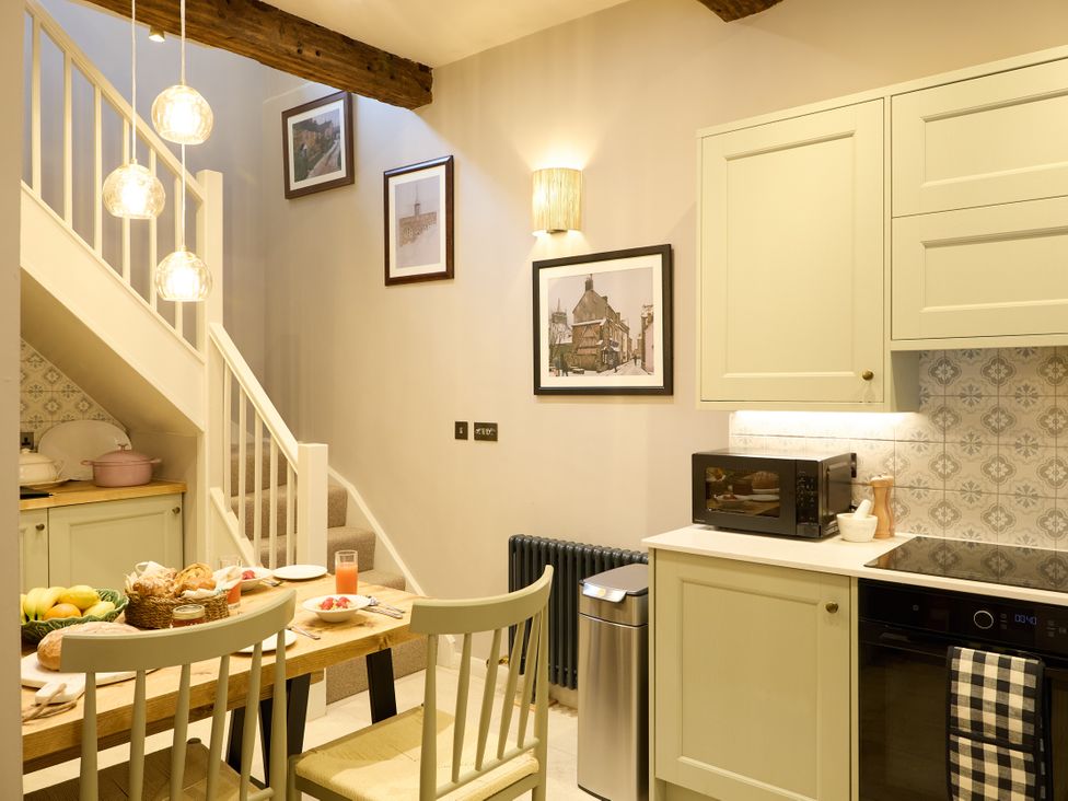 A kitchen with a table and chairs at The Dovecote in Matlock
