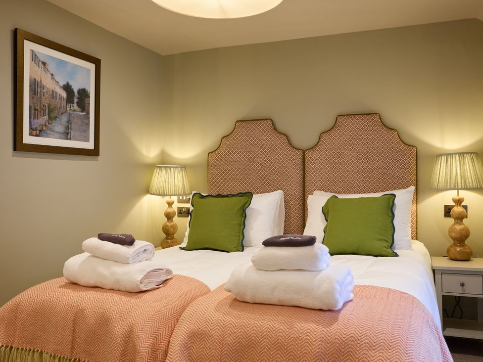A bedroom with two beds and towels at The Dovecote in Matlock