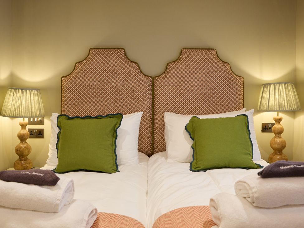 A bedroom with two beds and lamps on each side at The Dovecote in Matlock