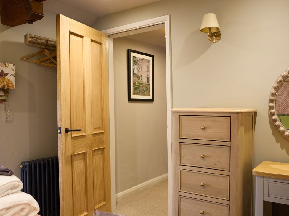 A bedroom with a door and a drawer unit at The Dovecote in Matlock