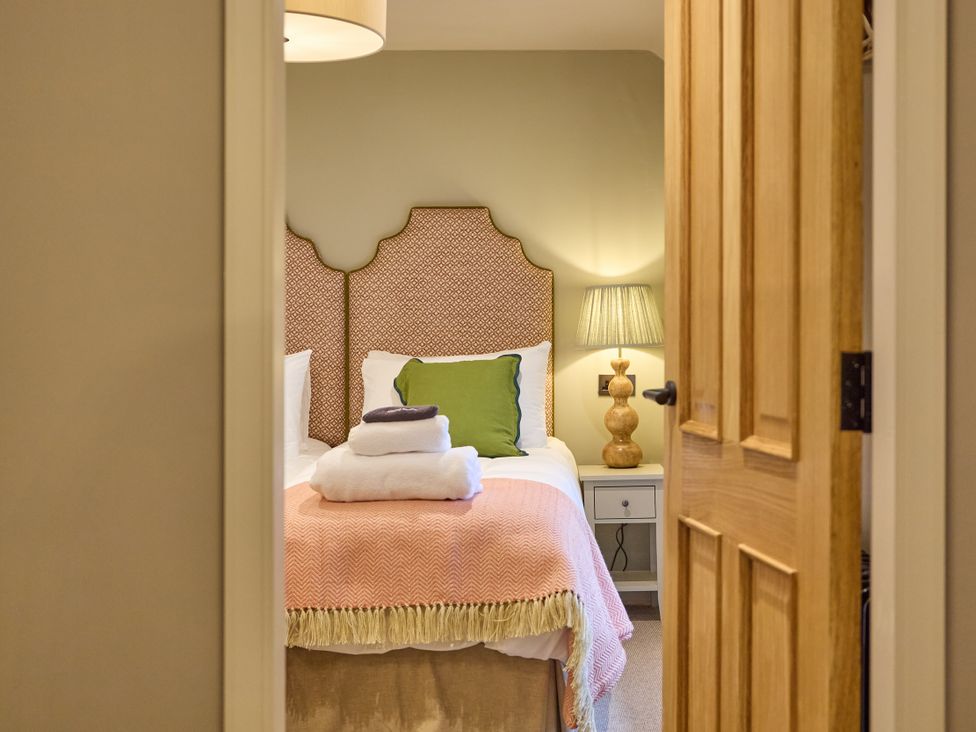 A bedroom with a bed and a lamp at The Dovecote in Matlock