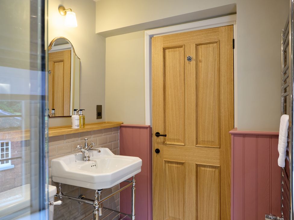 A bathroom with a sink and door at The Dovecote in Matlock