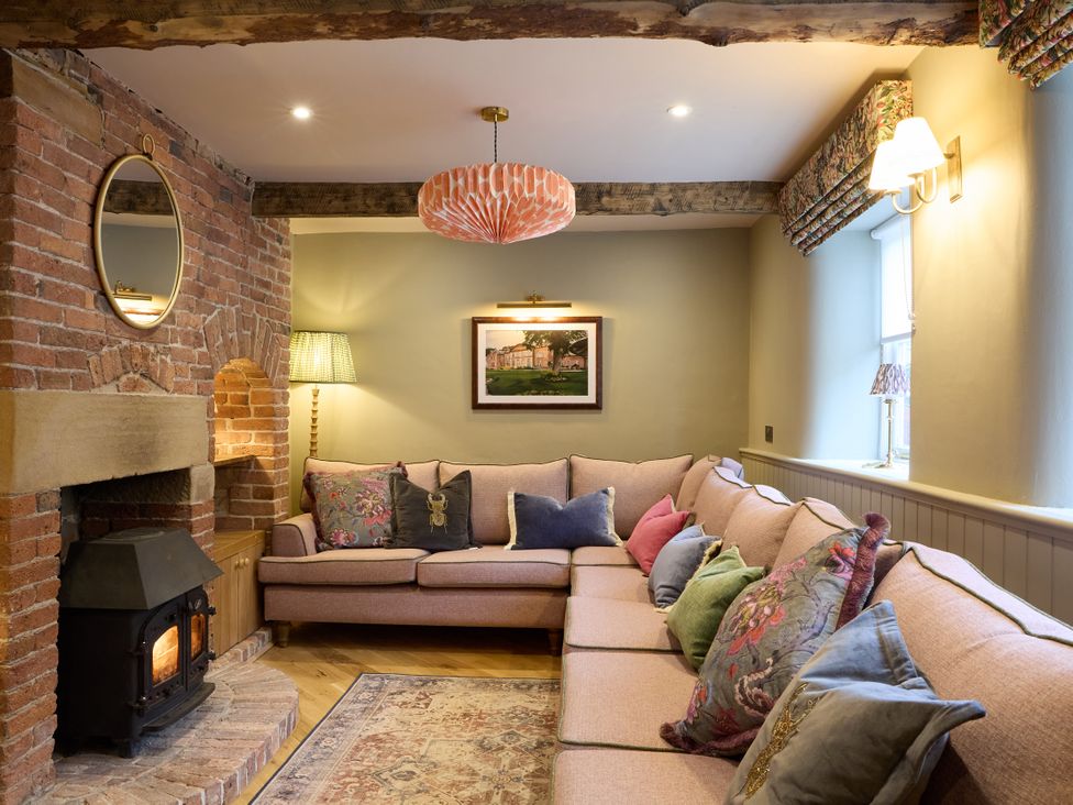 A living room with a sofa and fireplace at Butler's Quarters in Matlock