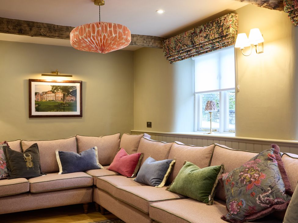 A living room with a sofa and decorative pillows at Butler's Quarters in Matlock