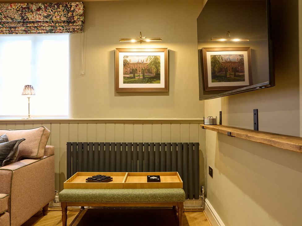 A living room with a sofa, lamp, and coffee table at Butler's Quarters in Matlock