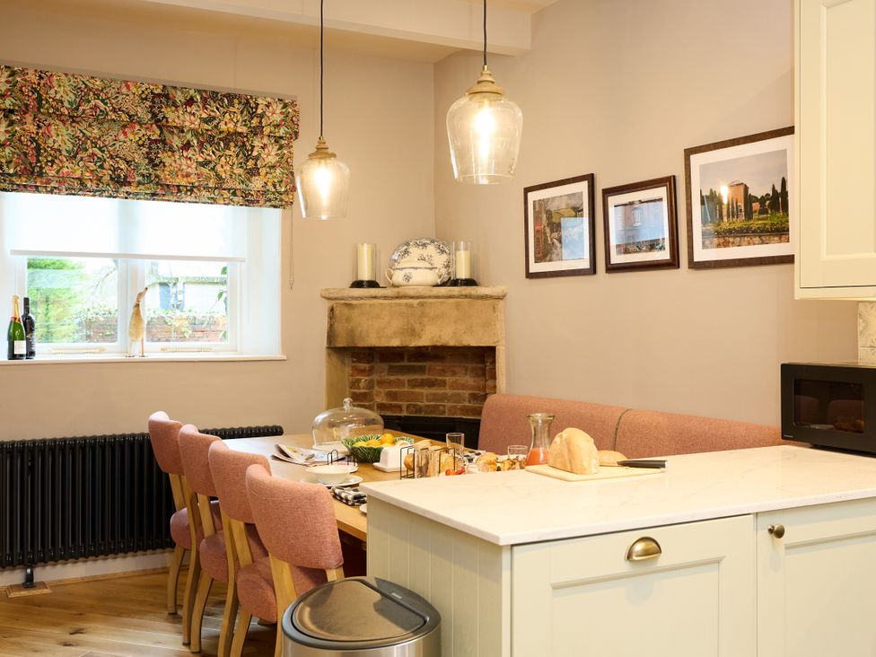 A kitchen with a table and chairs at Butler's Quarters in Matlock