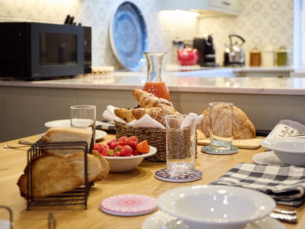 A kitchen with bread and juice on the table at Butler's Quarters in Matlock