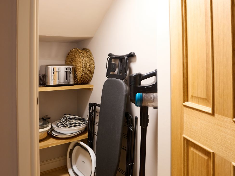 A storage room with shelves containing kitchen items at Butler's Quarters in Matlock
