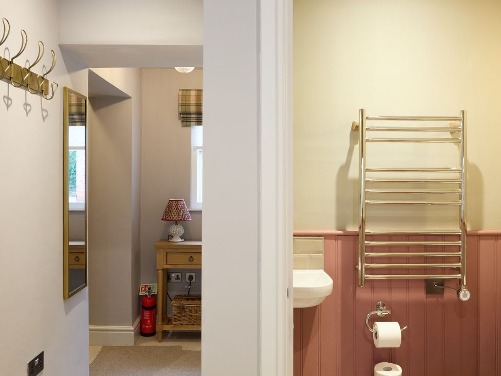 A bathroom with a towel warmer and sink at Butler's Quarters Matlock