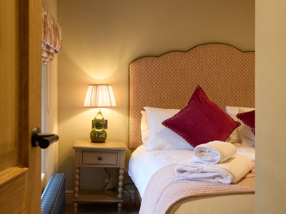 A bedroom with a bed and bedside table at Butler's Quarters in Matlock