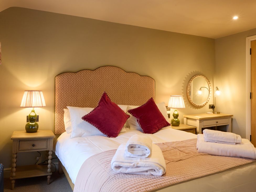 A bedroom with a bed and bedside table at Butler's Quarters in Matlock