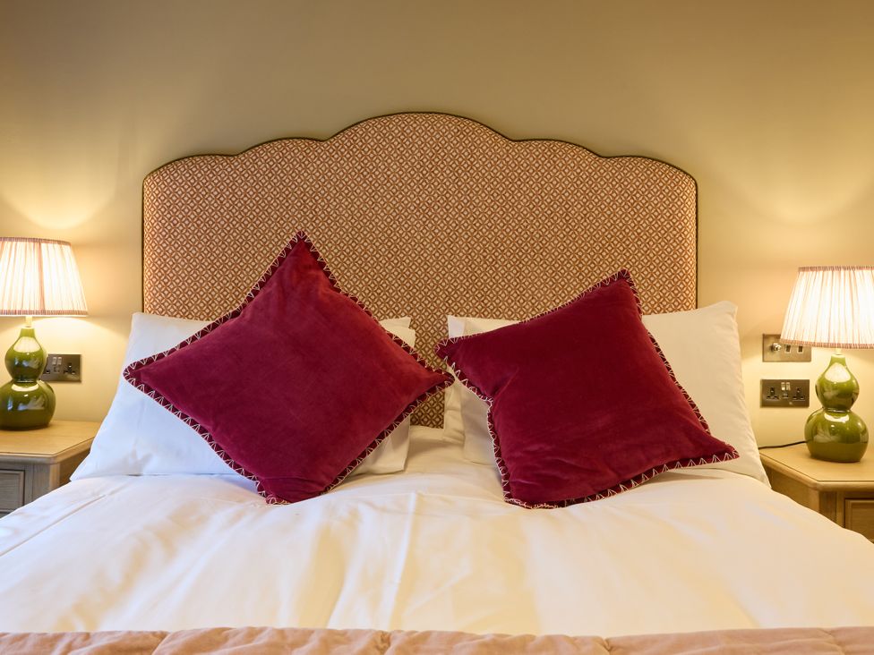 A bedroom with a bed and pillows at Butler's Quarters in Matlock