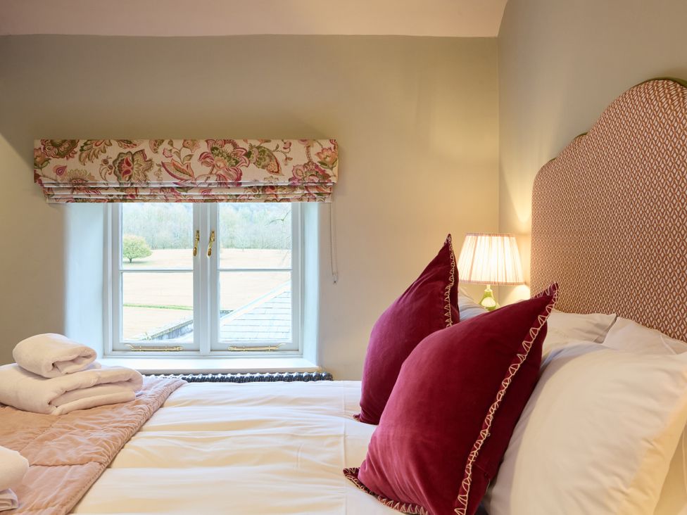 A bedroom with a bed and window at Butler's Quarters in Matlock