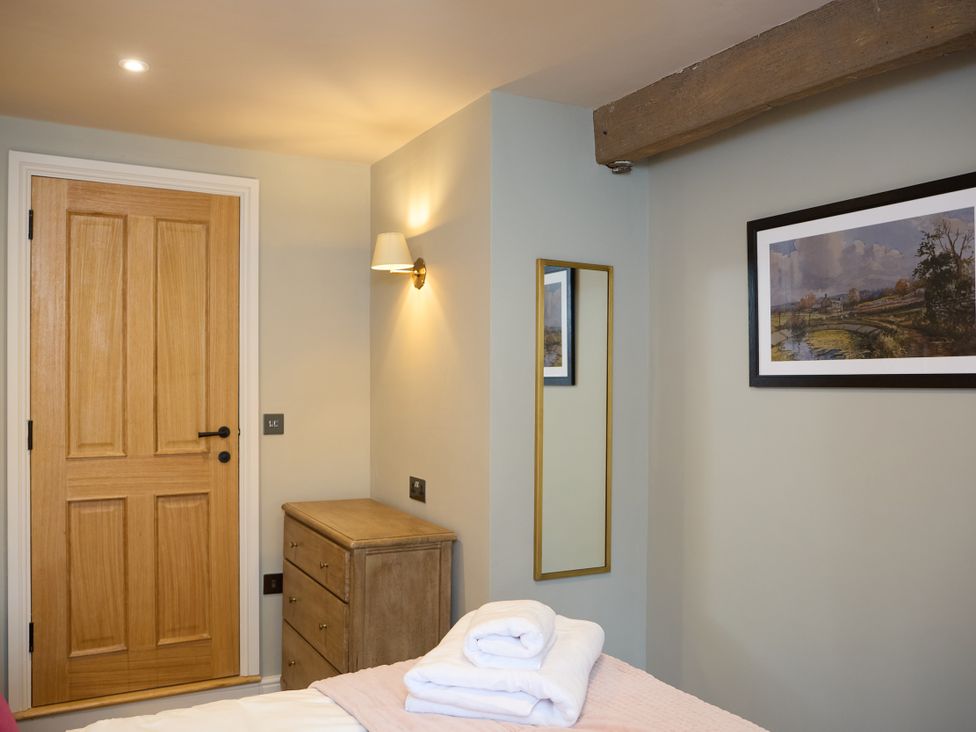 A bedroom with a door and drawer cabinet at Butler's Quarters in Matlock