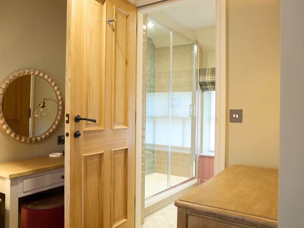 A bathroom with a shower and a mirror at Butler's Quarters in Matlock