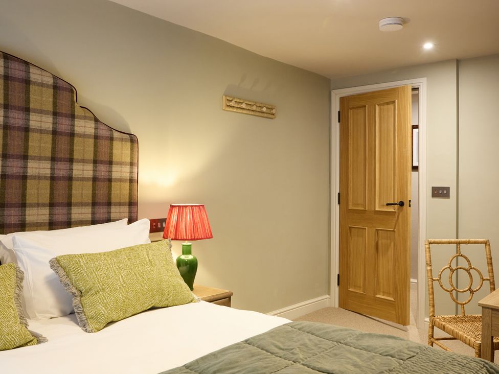 A bedroom with a bed and lamp at Butler's Quarters Matlock