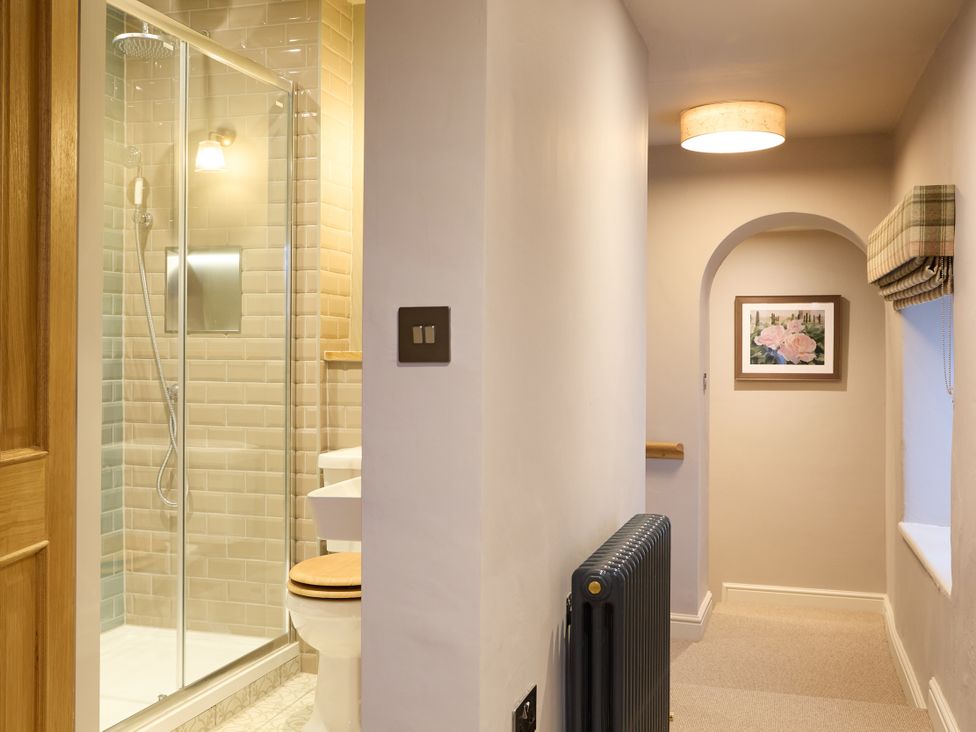 A bathroom with a shower and toilet at Butler's Quarters in Matlock