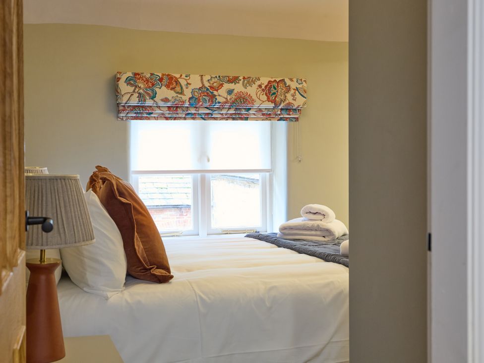 A bedroom with a bed and pillows at Butler's Quarters in Matlock