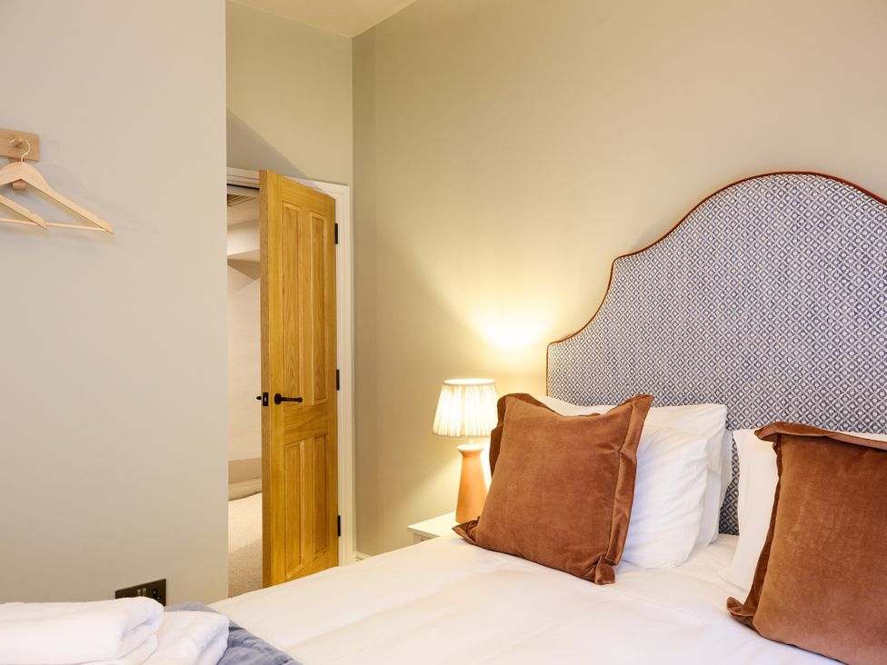 A bedroom with a bed and door at Butler's Quarters in Matlock