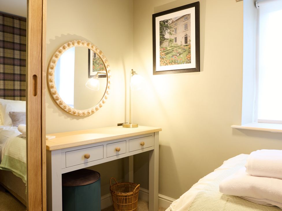 A bedroom with a desk and mirror at Butler's Quarters in Matlock