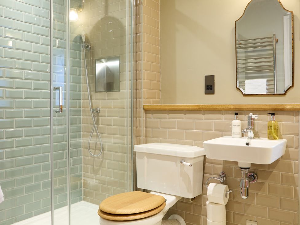 A bathroom with a shower, toilet, and sink at Butler's Quarters in Matlock