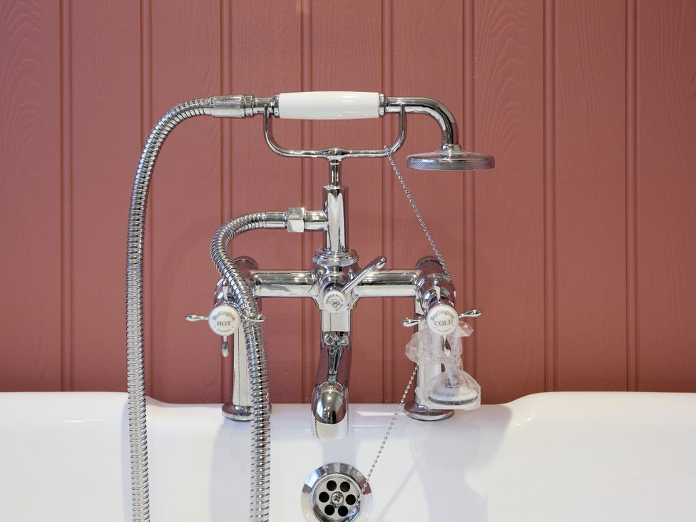 A bathtub faucet with hot and cold knobs at Butler's Quarters in Matlock