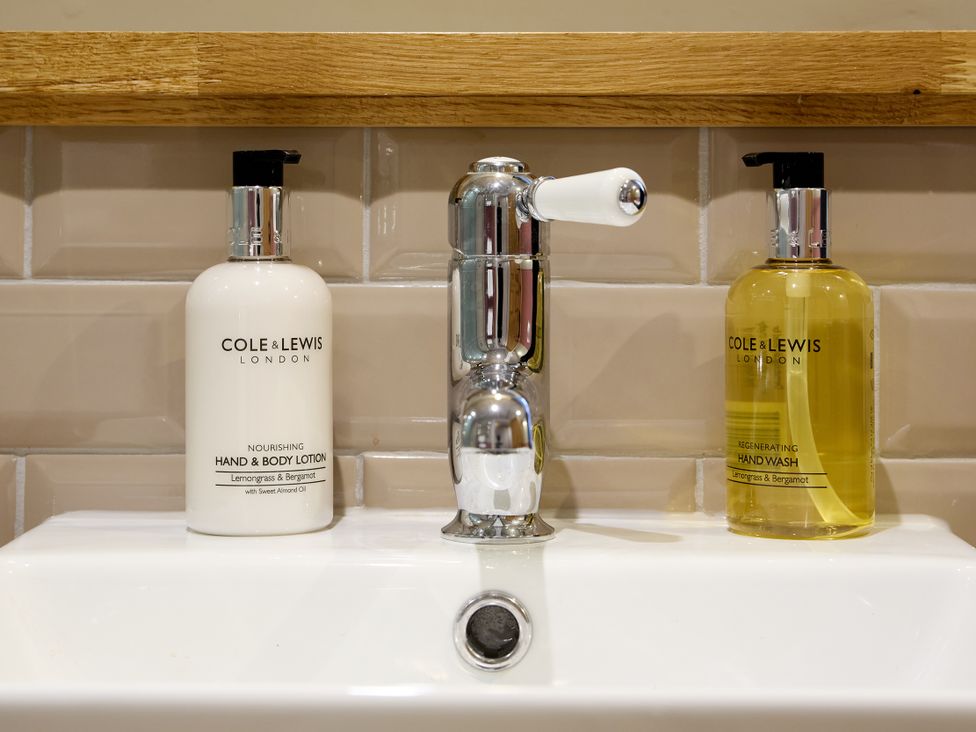A sink with hand wash and lotion dispensers at Butler's Quarters in Matlock