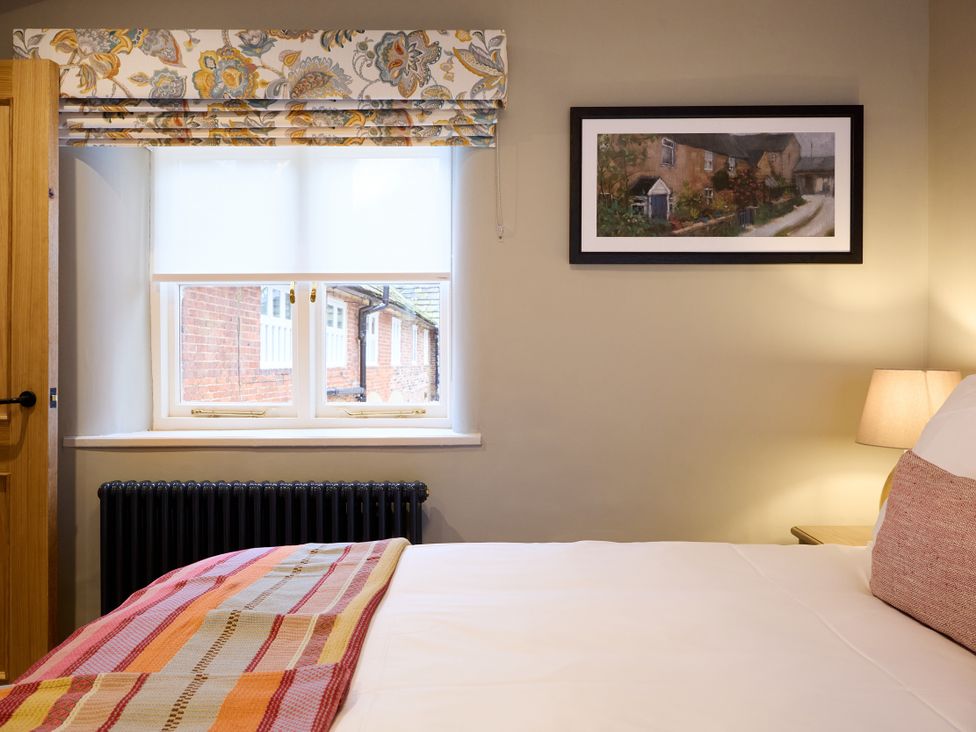 A bedroom with a bed and window at Butler's Quarters in Matlock