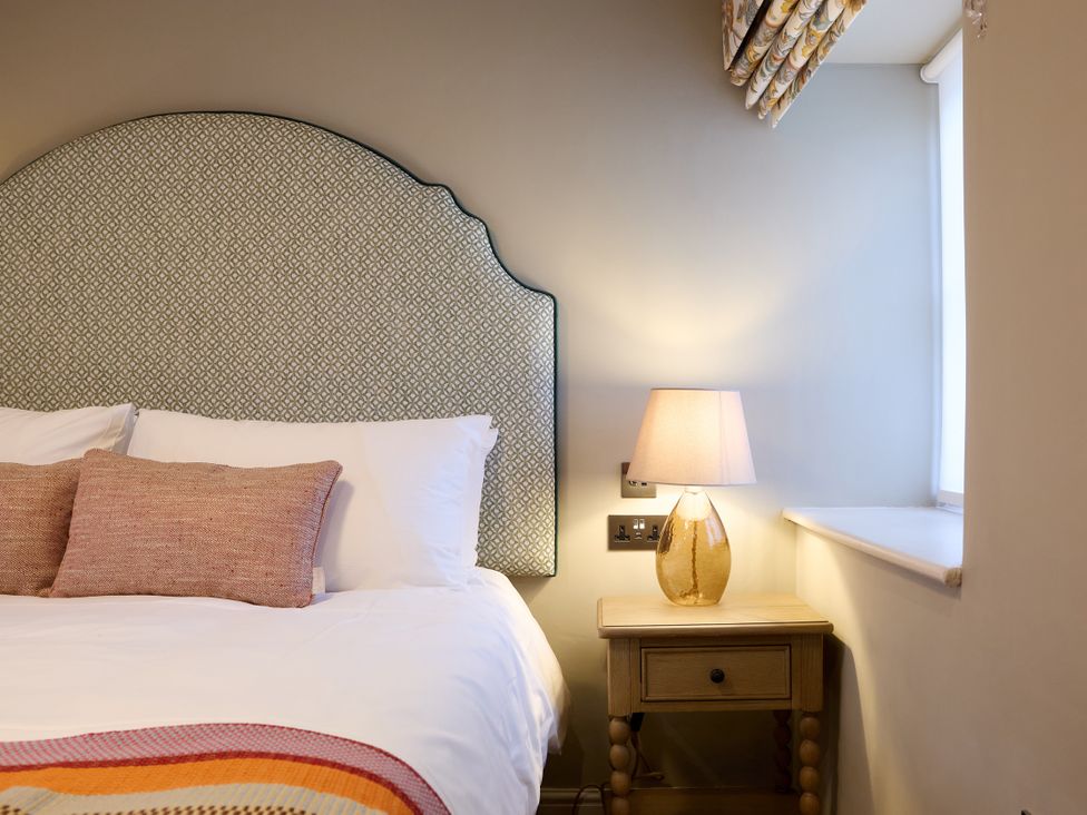 A bedroom with a bed and lamp at Butler's Quarters in Matlock