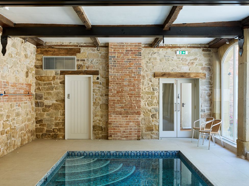 An indoor pool area with a swimming pool and seating at Butler's Quarters in Hopton