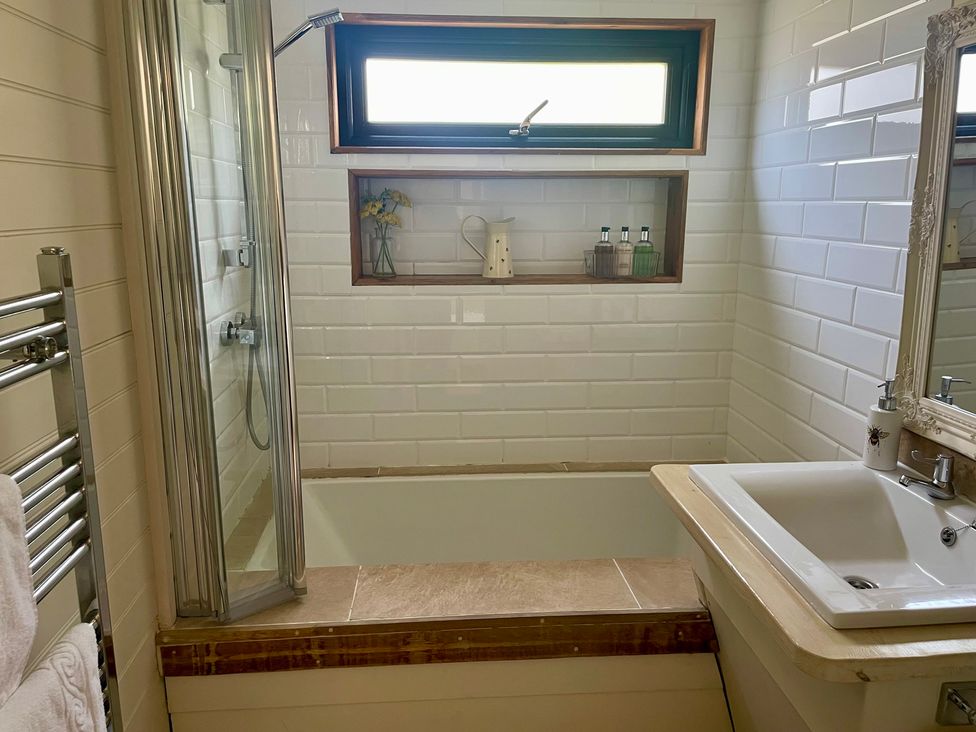 A bathroom with a bathtub and sink at The Cow Shed in Mawgan Porth