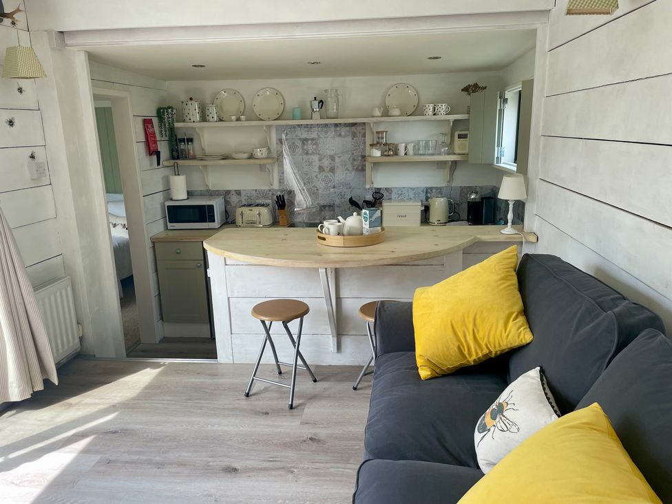 A kitchen with a countertop and seating area at The Cow Shed in Mawgan Porth